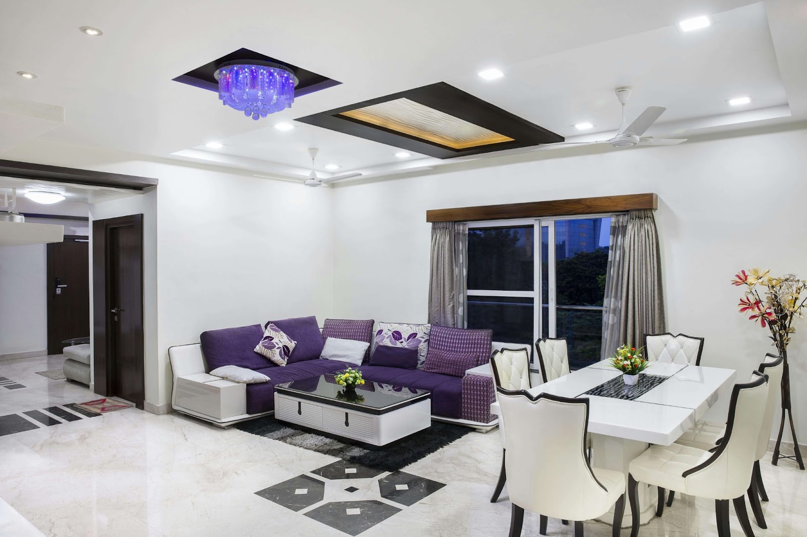 A living room featuring purple furniture against white walls, showing recent plaster repair work.