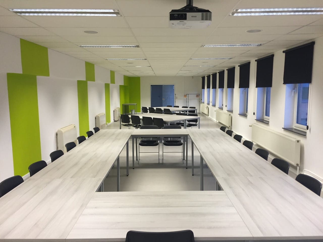 A well-organized conference room featuring tables and chairs, showing Athena Best Painting Services' professional environment.